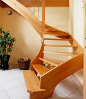 Massivholztreppe aus Buche, integriert in die Raumgestaltung durch offenen Zugang. Kombiniert mit Edelstahl.
